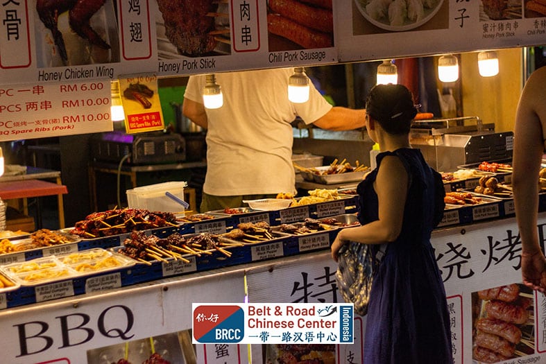 Perempuan berbelanja street food jajanan kaki lima di pasar malam China