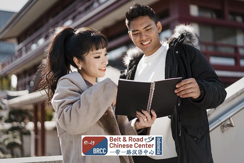 Dua mahasiswa internasional belajar bersama menggunakan laptop di kampus Tiongkok