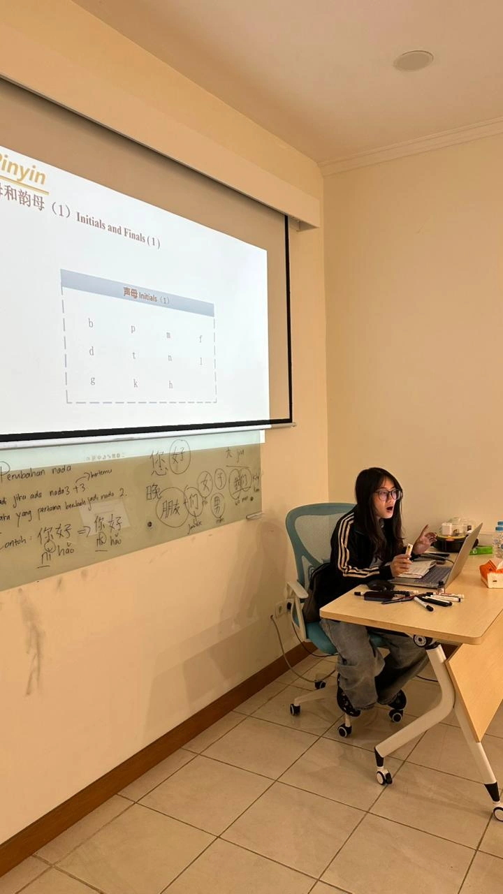 Materi pinyin dan perubahan nada Penjelasan materi pinyin beserta catatan perubahan nada di papan tulis kelas bahasa Mandarin