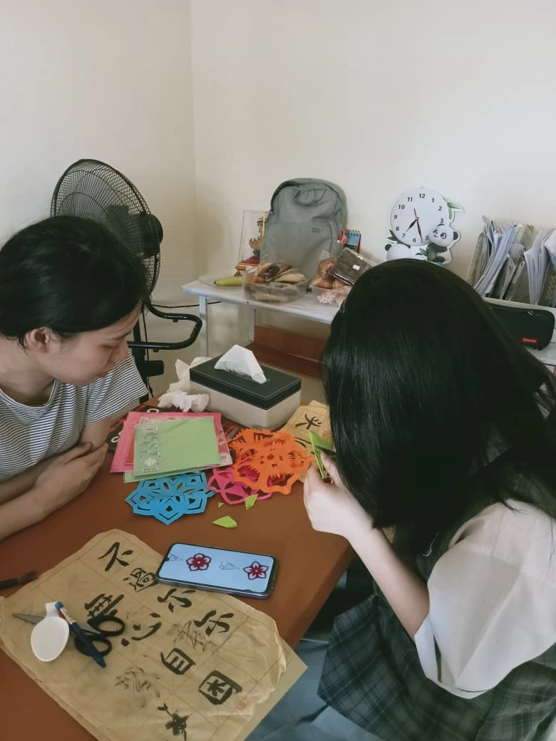 Praktik jianzhi dan kaligrafi dalam kelas bahasa Mandarin Siswa mempraktikkan seni potong kertas jianzhi dan kaligrafi Tiongkok di kelas bahasa Mandarin